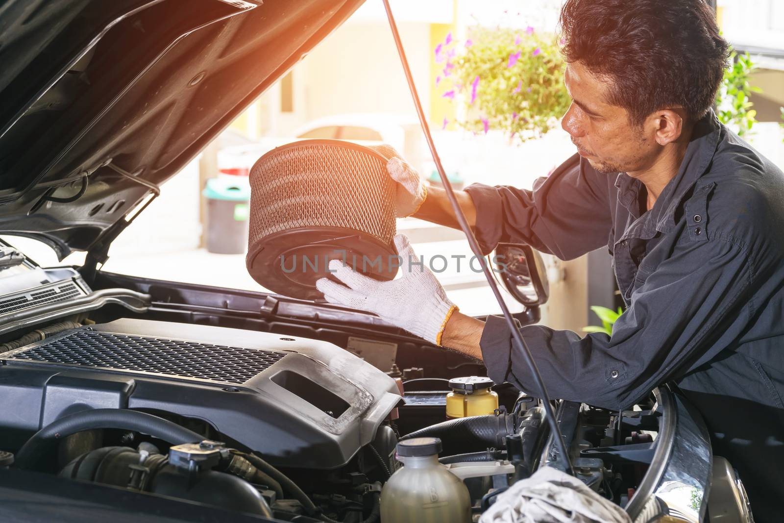 The technician removes the car's air filter for inspection and cleaning, Automotive industry and garage concepts.