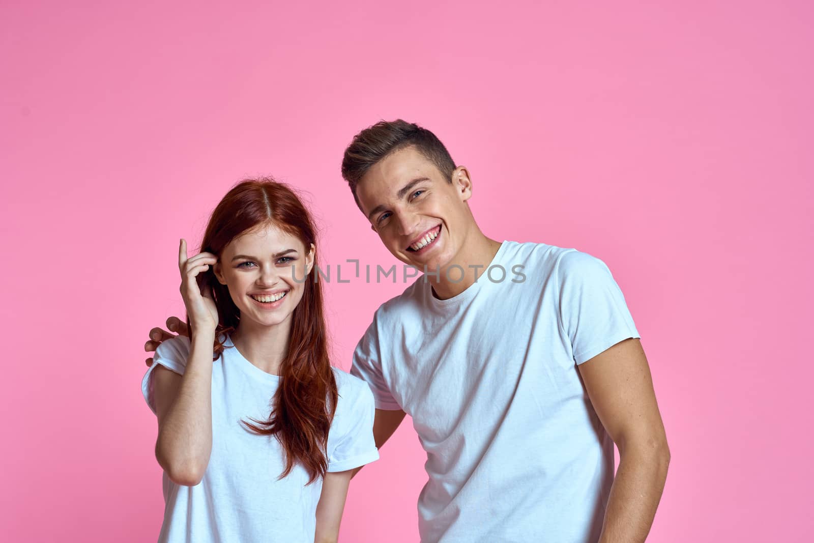 enamored man and woman hugging each other on a pink background cropped with Copy Space family portrait. High quality photo