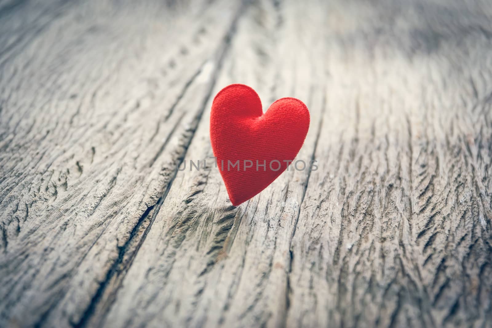 Red heart on wooden floor with copy space for text, used in love concept on Valentine's Day.