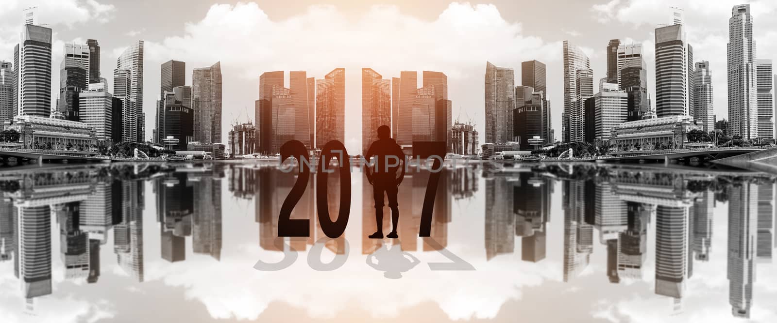 Silhouette of young man standing between 2017 years with beautiful blurred city background.