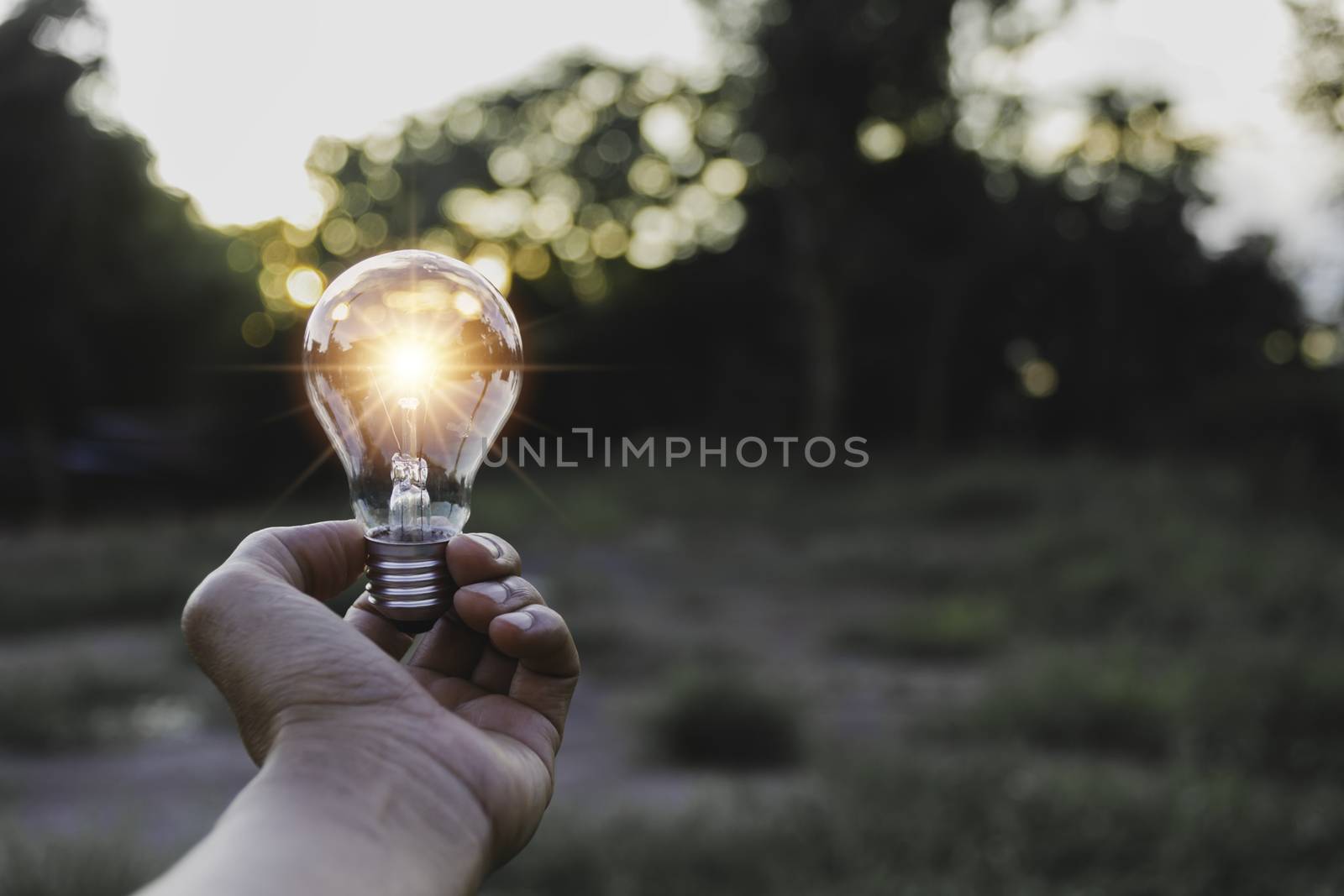 Innovation and energy concept of hand hold a light bulb and copy by kirisa99