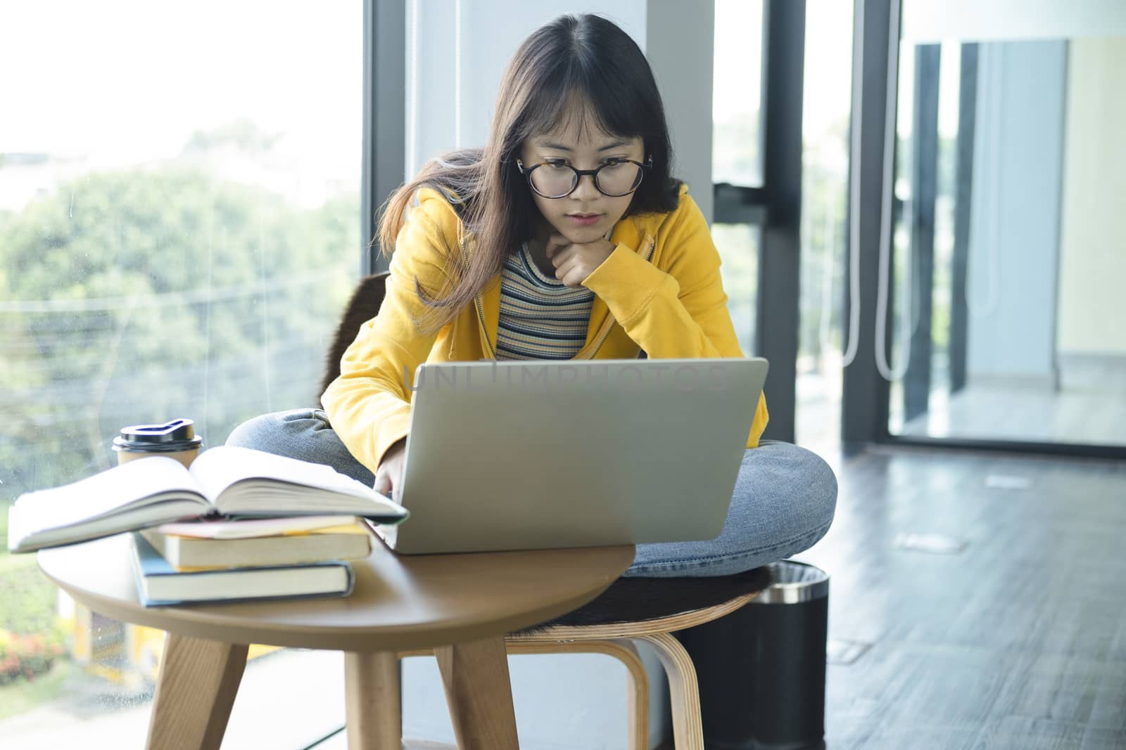 Young collage student using computer and mobile device studying online. Education and online learning. 