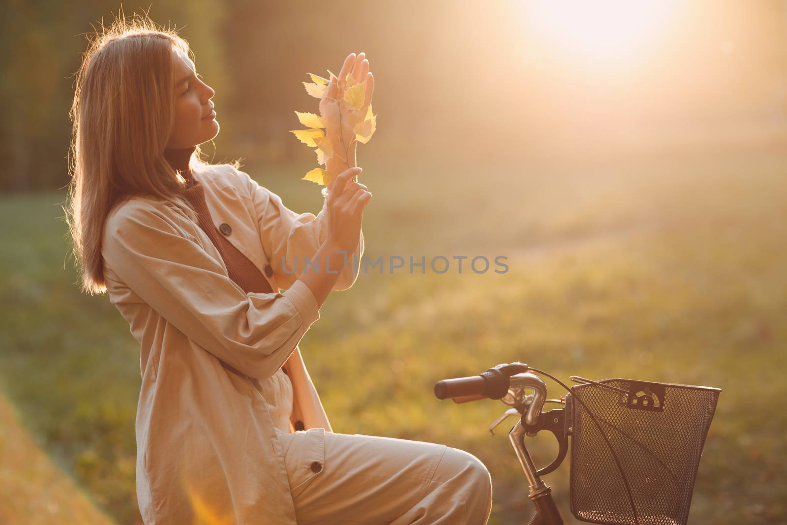 Happy active young woman riding bicycle in autumn park.