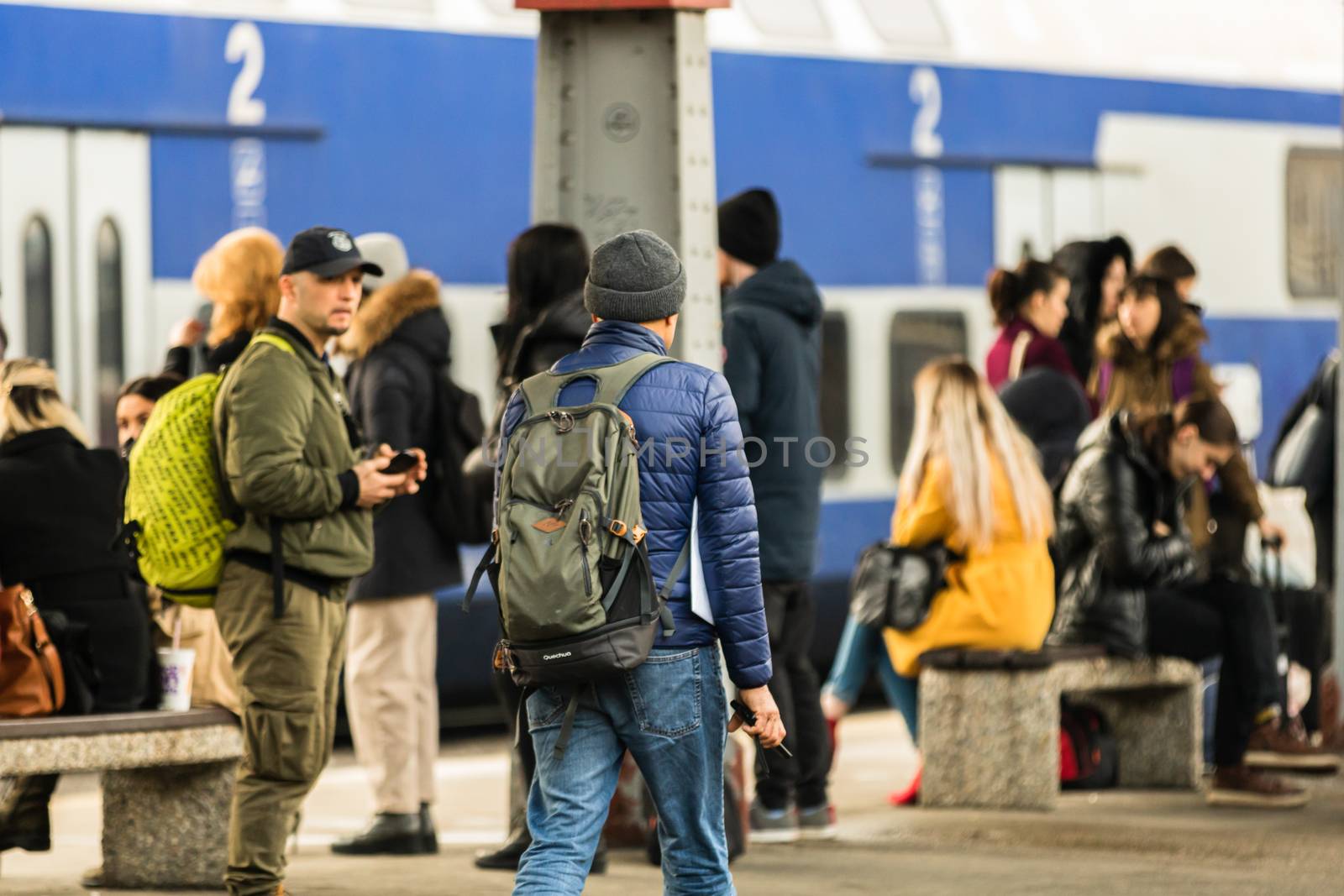 Travelers and commuters carry luggage and backpacks on the train platform of Bucharest North Railway Station (Gara de Nord Bucharest) in Bucharest, Romania, 2020