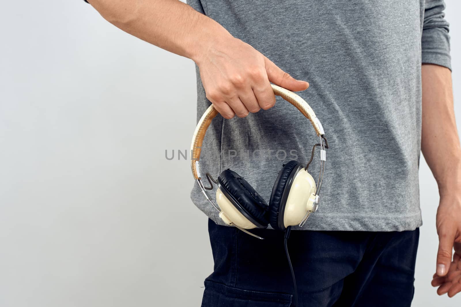 Man holding headphones in the hands of a man lifestyle modern style technology cropped view by SHOTPRIME