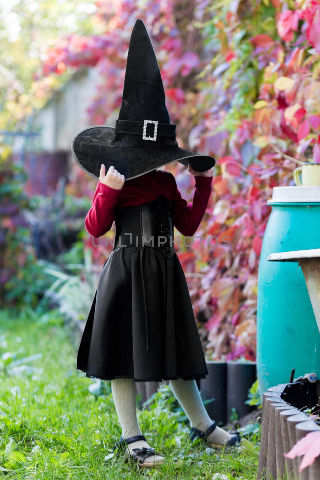 Little girl in witch costume posing on halloween party by galinasharapova