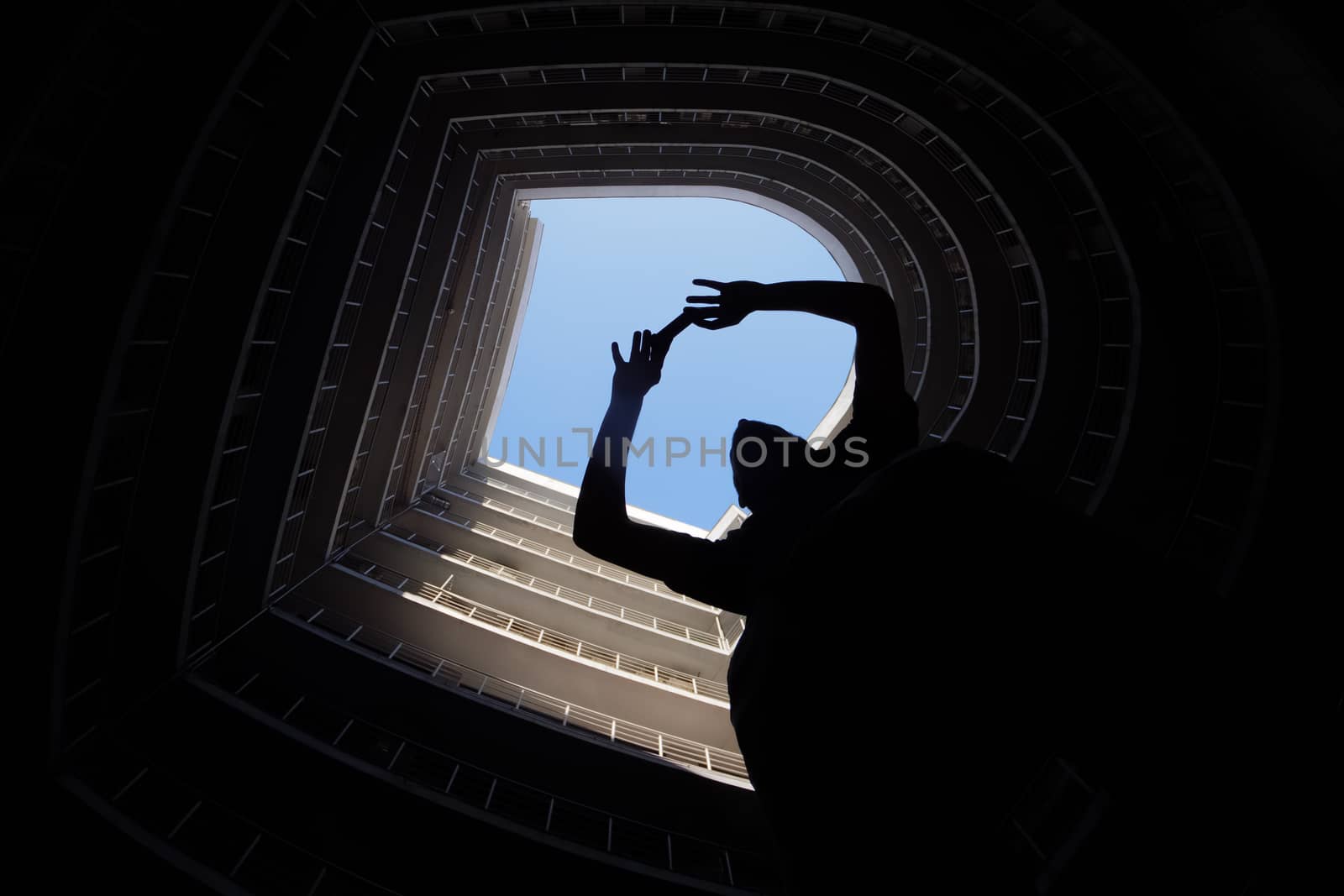Photographer in big city. Man taking a picture on smartphone or in urban city. Modern round building with blue sky on the top. Silhouette of a man taking the photo. Modern architecture concept