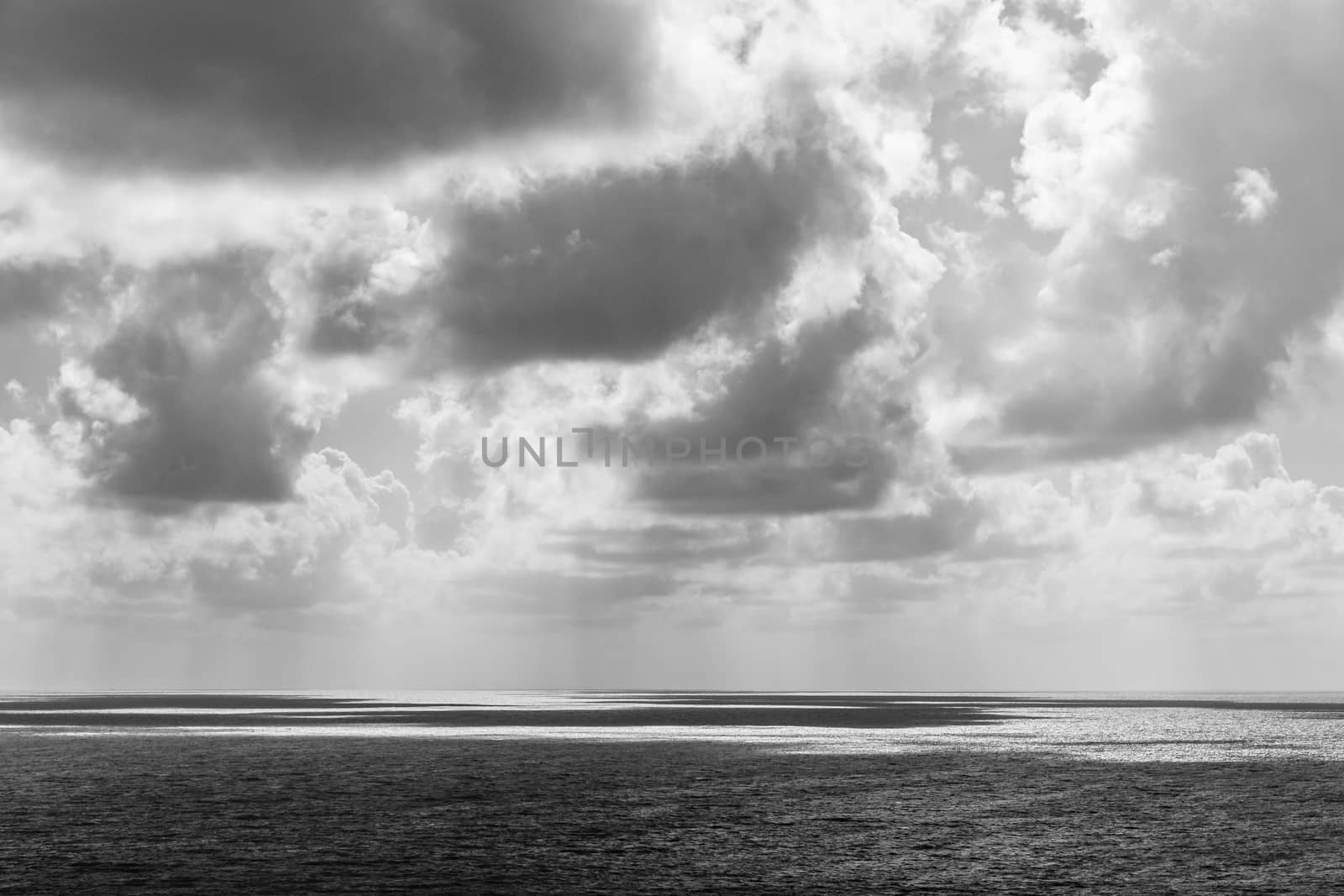Black and white of clouds casting their shadows on the sea surface. High contrast image captured in Queensland, Australia