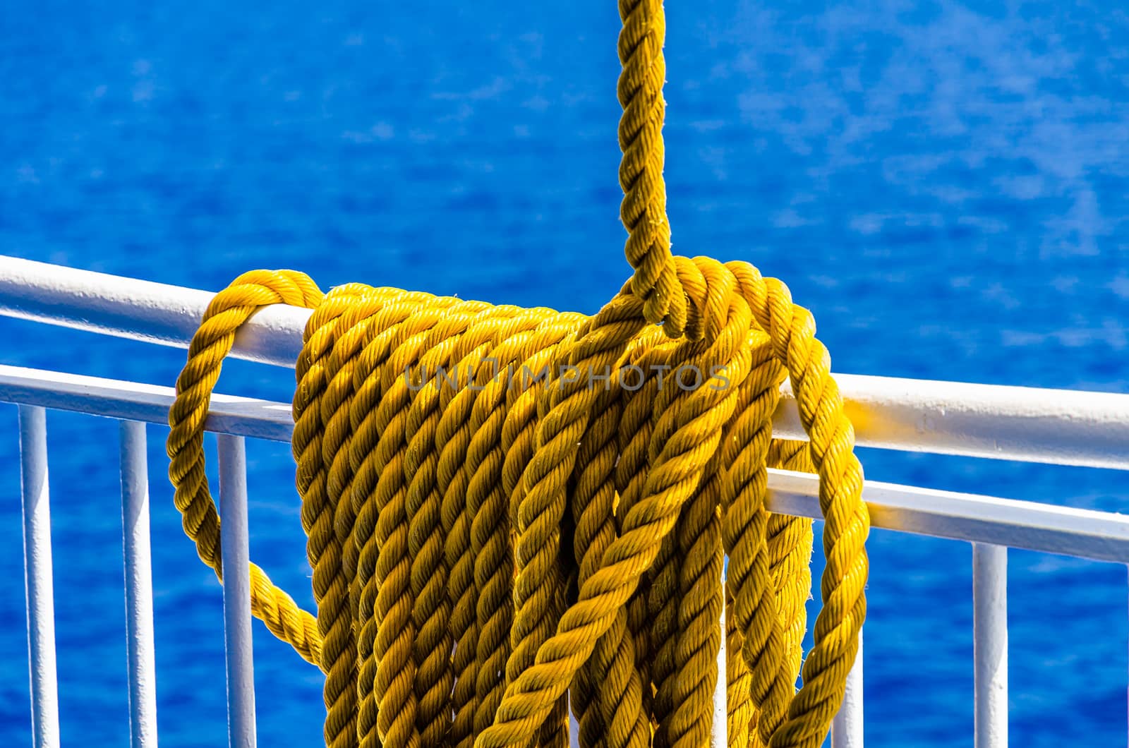 Yellow braided rope draped over a ship railing by mauricallari