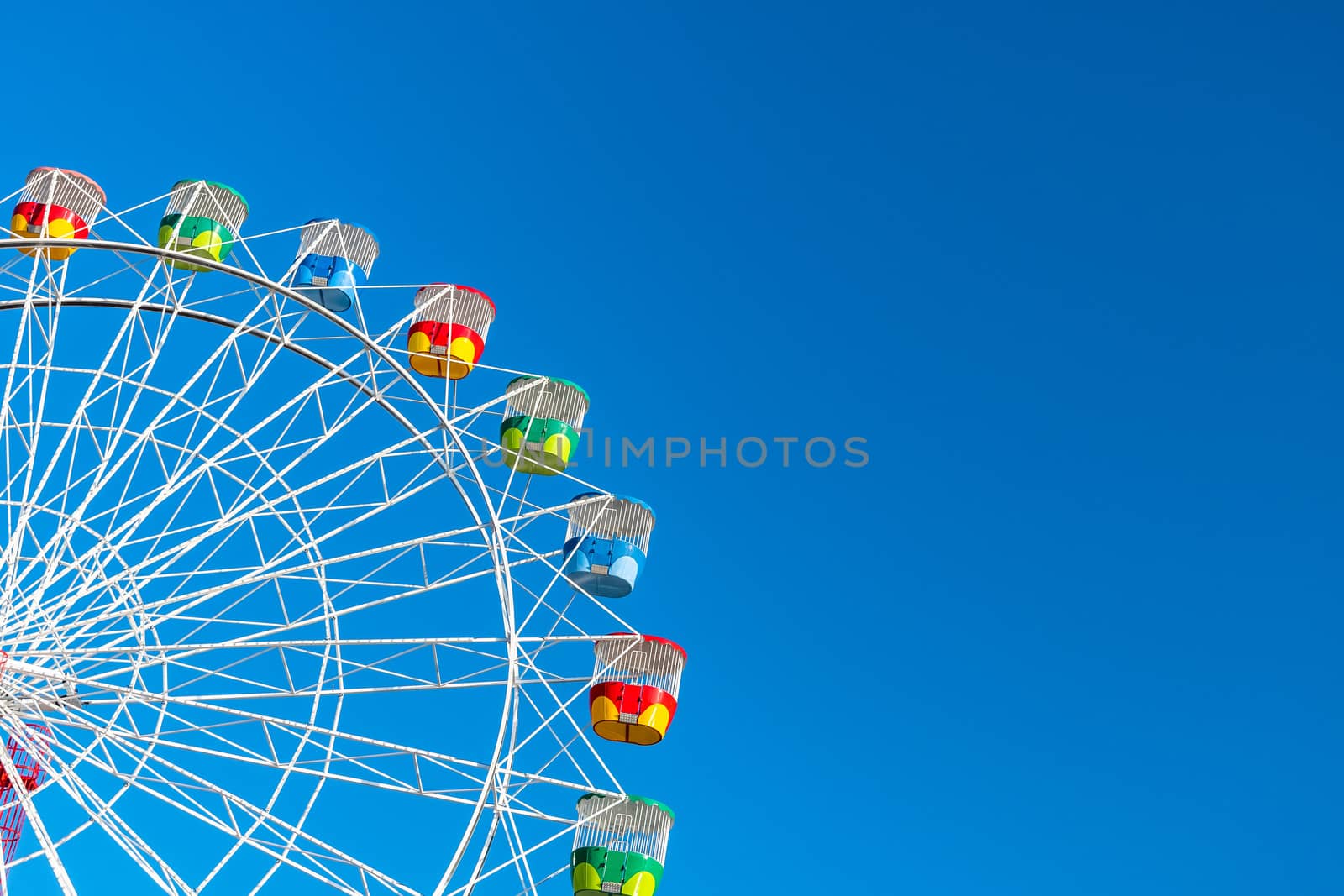 Ferris wheel with colourful rainbow seats in Sydney on clear blue sky background