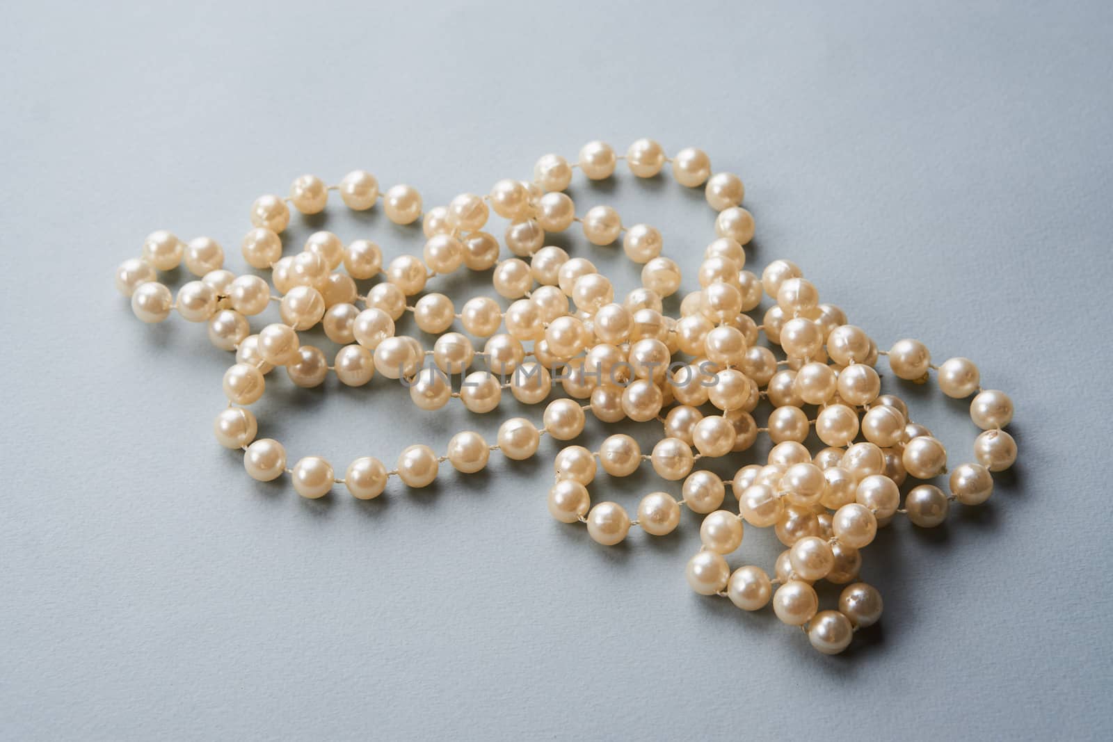 Pearl beads on a gray background decoration decoration top view by SHOTPRIME