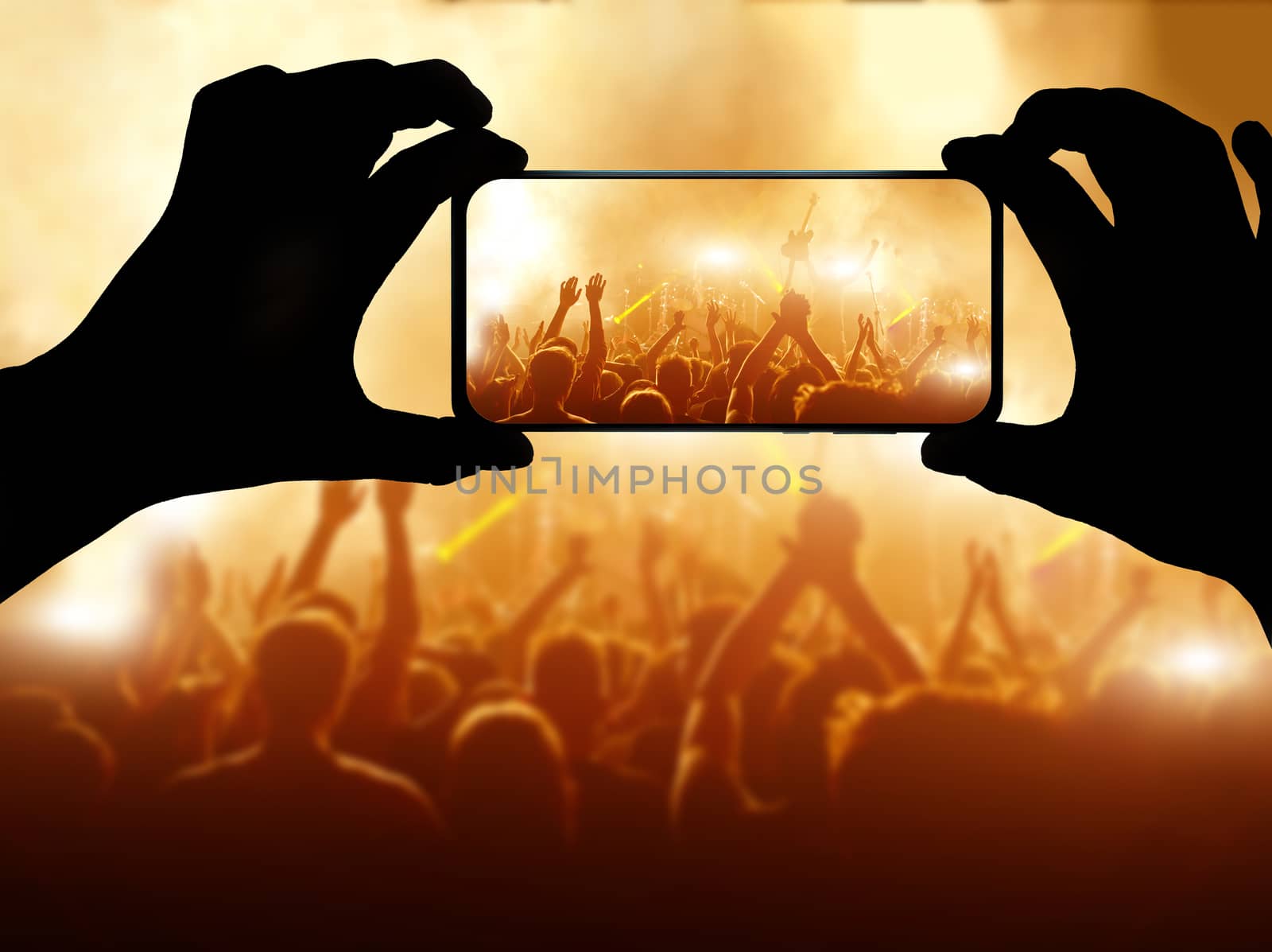 Silhouette of hand using camera phone to take pictures and videos at pop concert. Streaming to internet