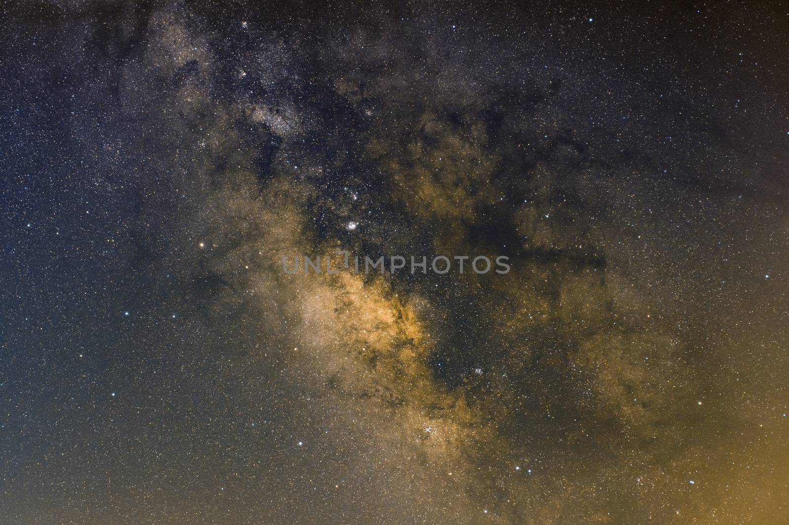 Central part of the Milky Way with Jupiter and Saturn on the left in a summer night in Sicily, Italy. Stacking of 10 images for signal to noise improvement