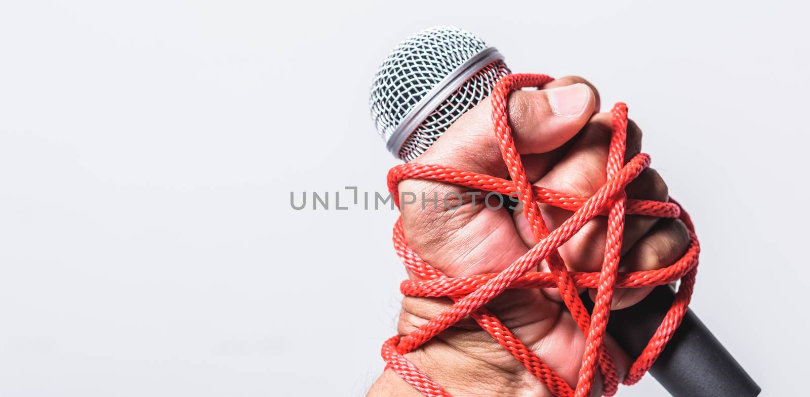 Hand holding microphone and have roped on fist hand on white background, Human rights day concept