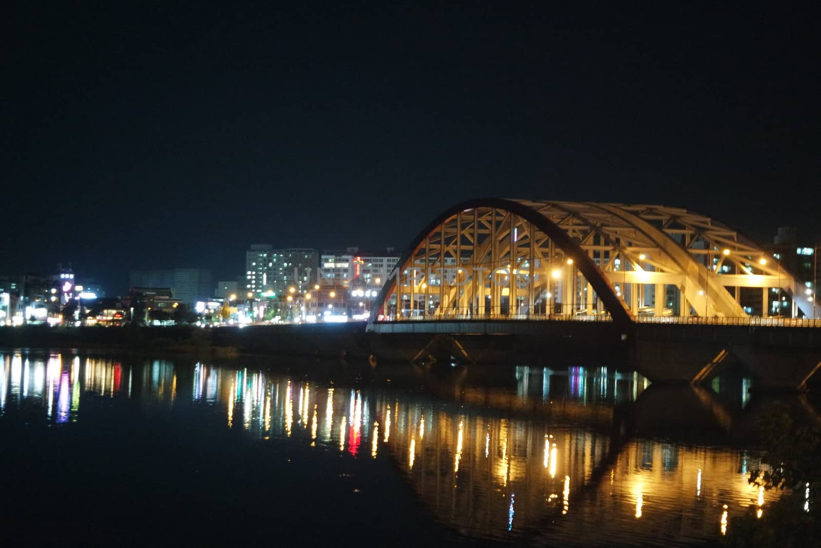 Night view of a beautiful scene of bridge over sea water in the evening time. by Photochowk