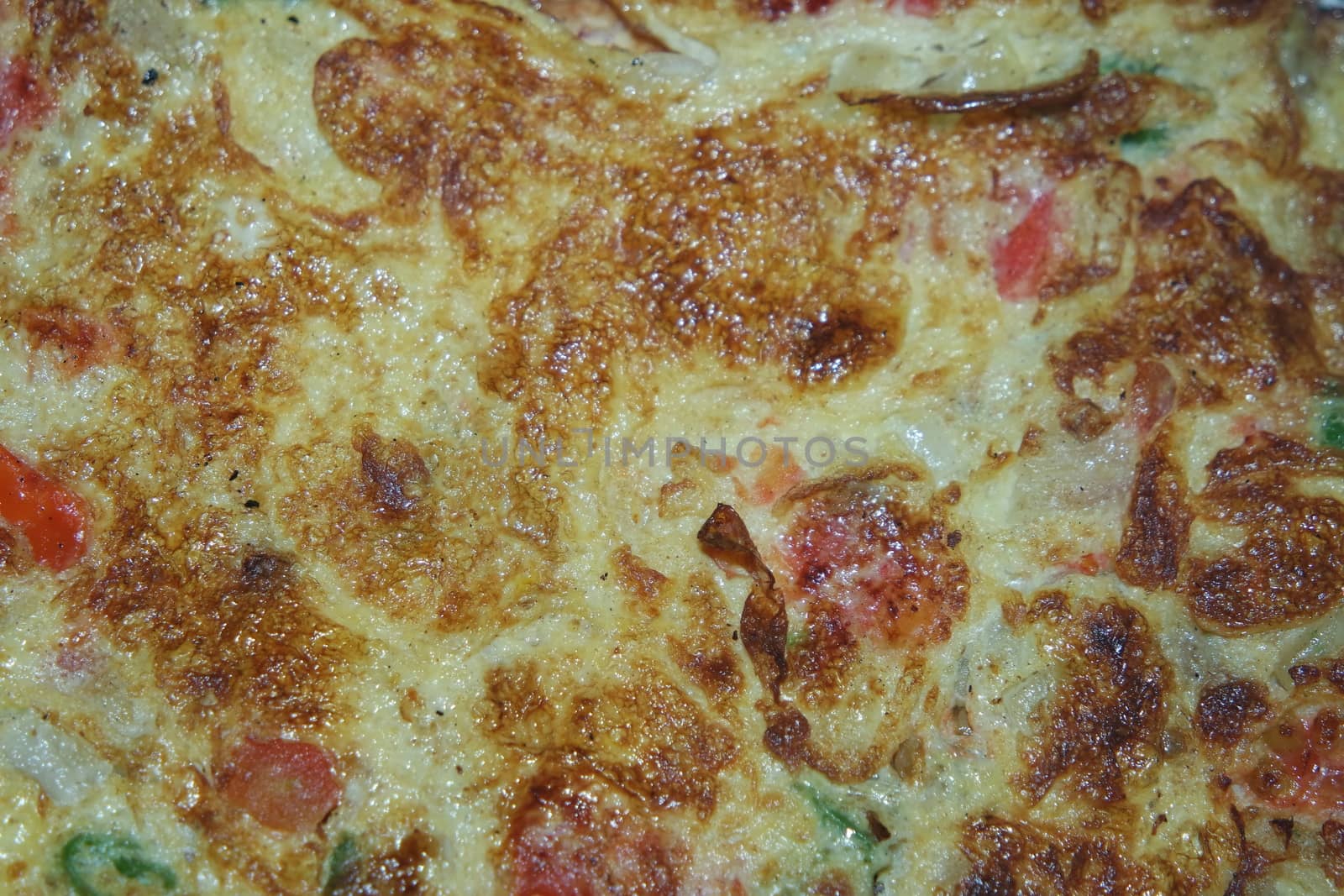 Close-up view with selective focus of egg omelet with peppers and spices sprinkled