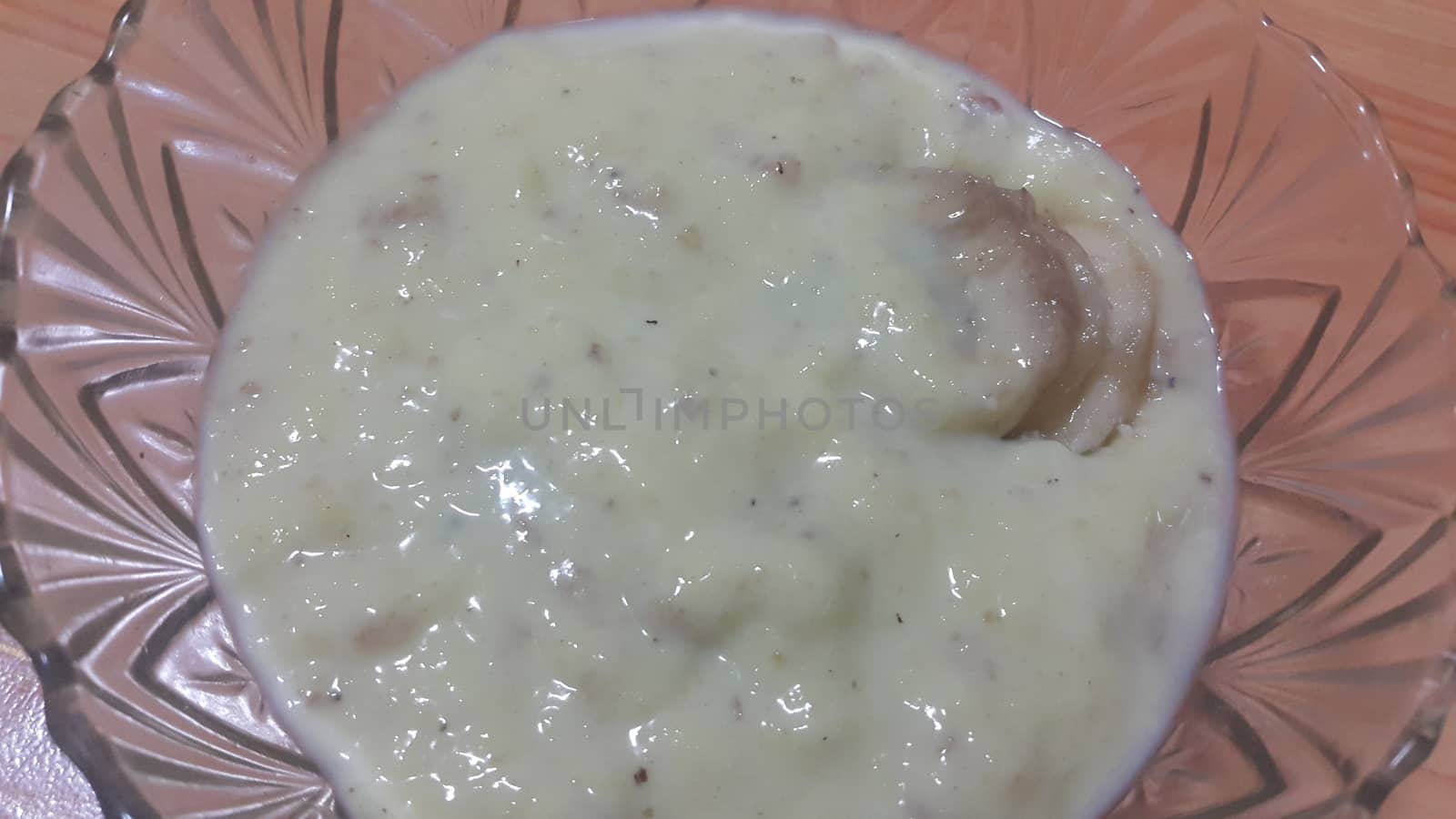 Creamy tasty sweet white rice pudding or Kheer in a glass bowl with banana slices layered on surface. A top view of home made pudding, a dairy products for dessert after meal.