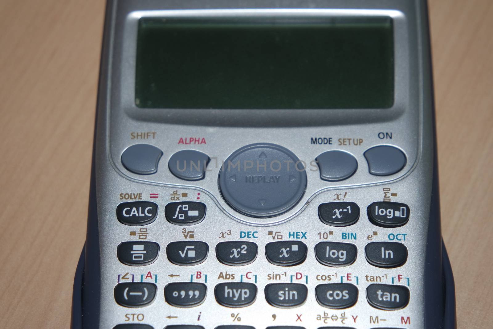 Calculator with colored keys or buttons isolated on a wooden background