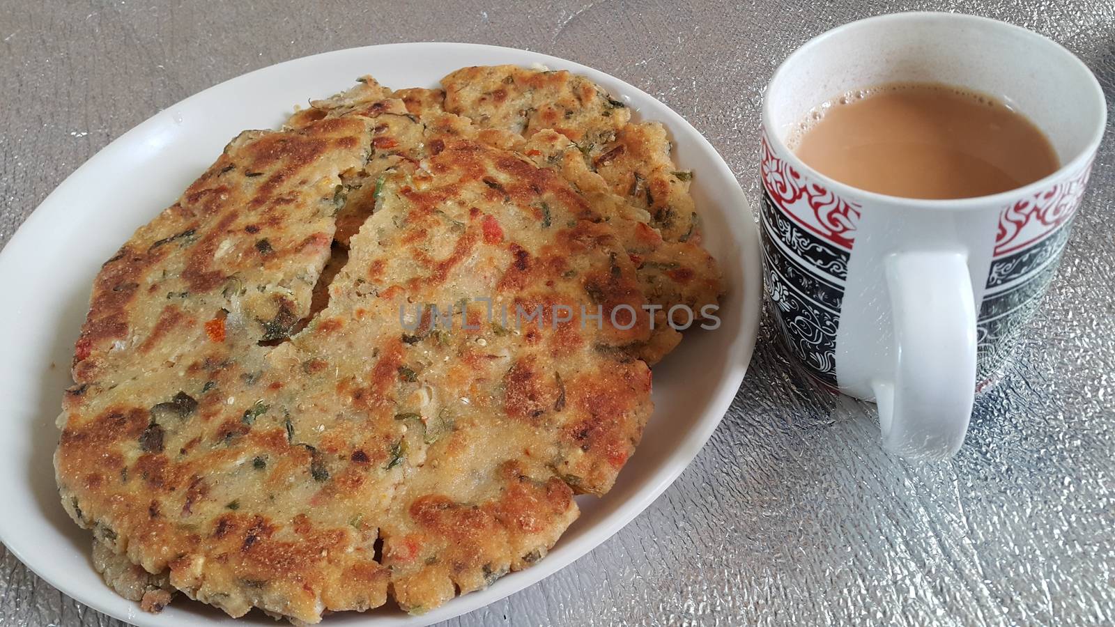 Closeup view of of traditional bread called Jawar roti or bhakri with tea cup. Bhakri is a round flat unleavened bread often used in the cuisine of many Asian countries