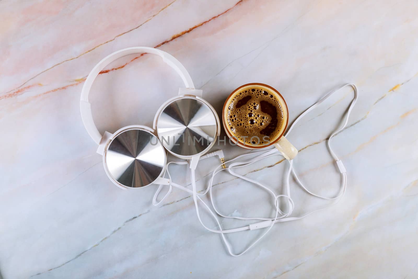 Headphones with cup of black coffee espresso on marble background