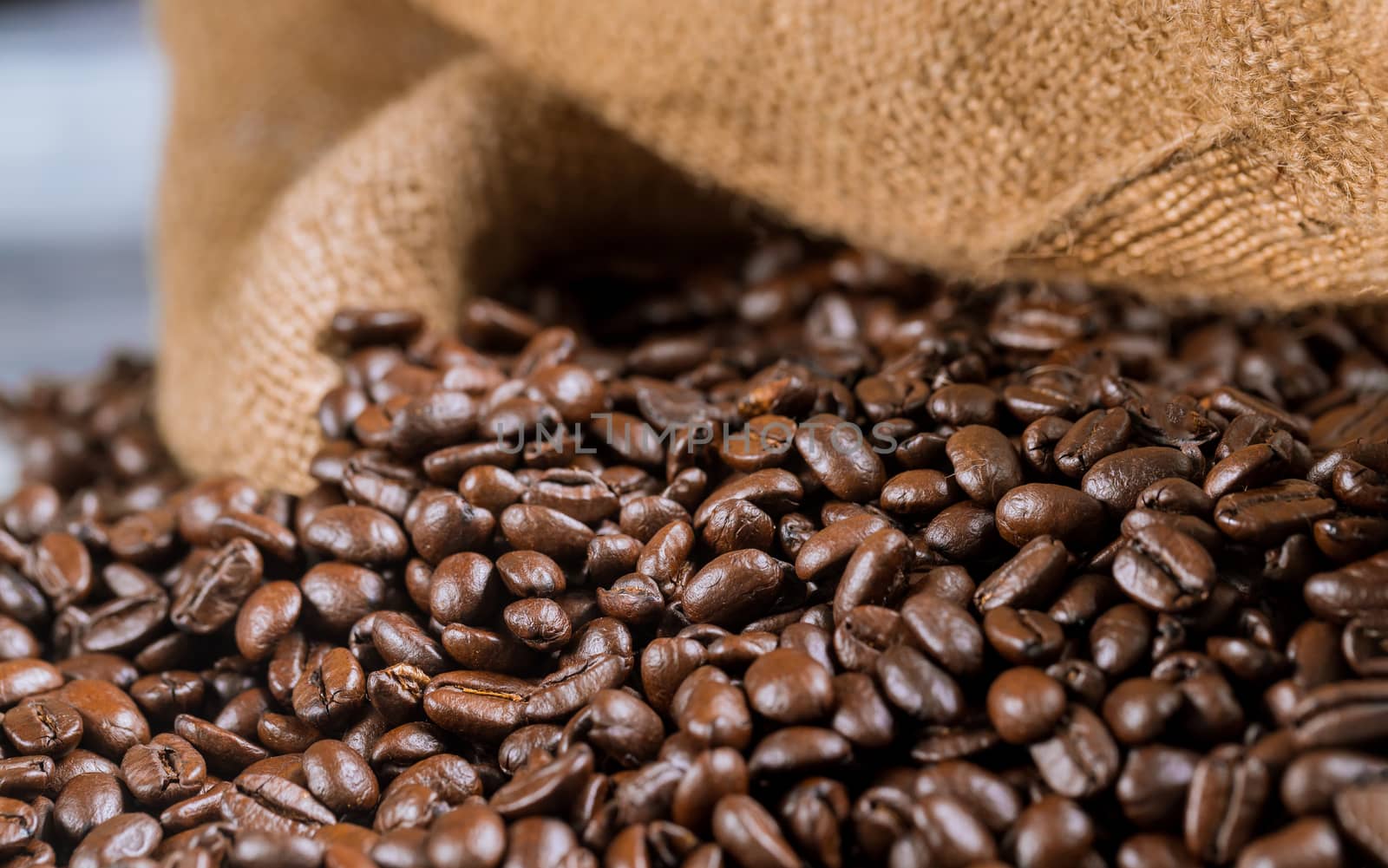 Black coffee beans in fabric bag. Close up.