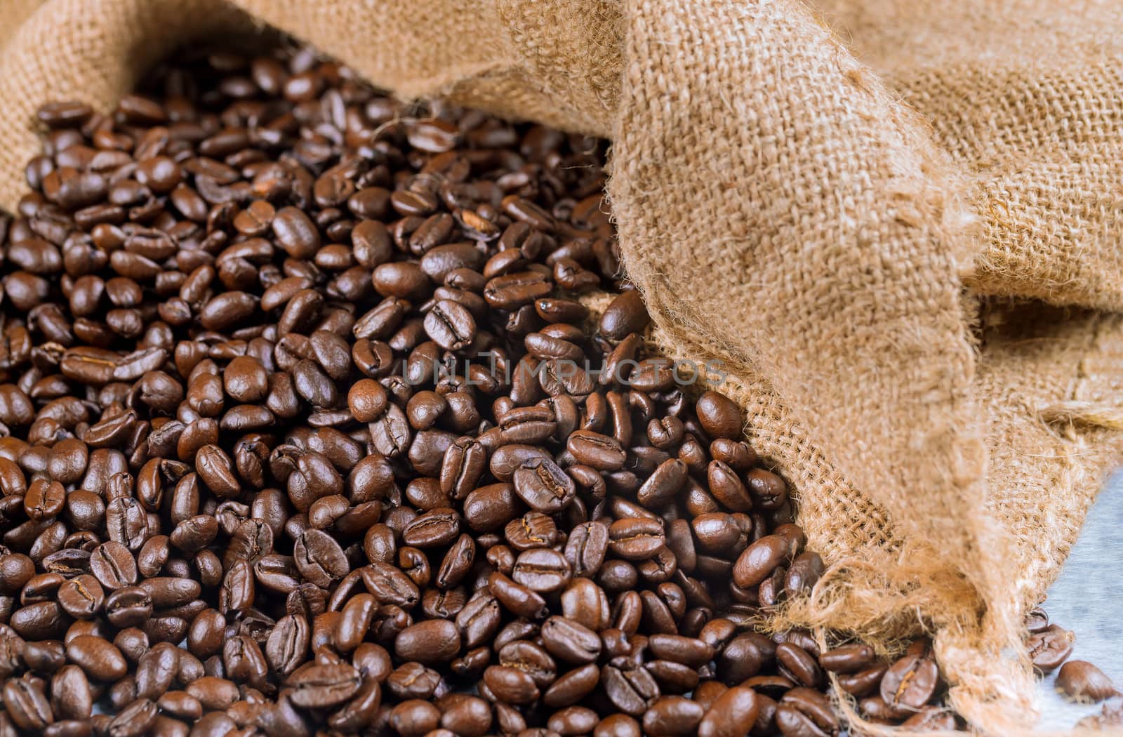 Black coffee beans in a bagging. Close up.