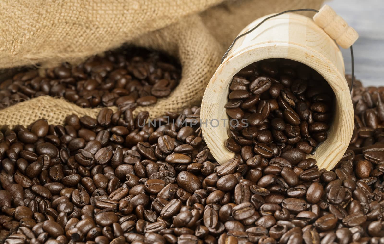 Black coffee beans with wooden cup and bag.