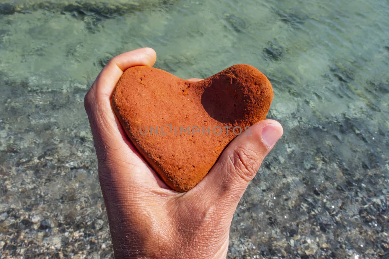 orange heart shaped stone at the beach