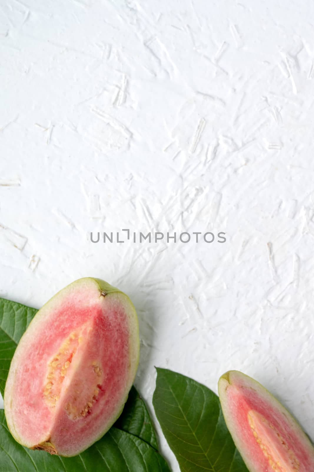 Top view, flat lay of delicious beautiful Red guava with fresh green leaves isolated on white table background, studio overhead table shot with copy space.