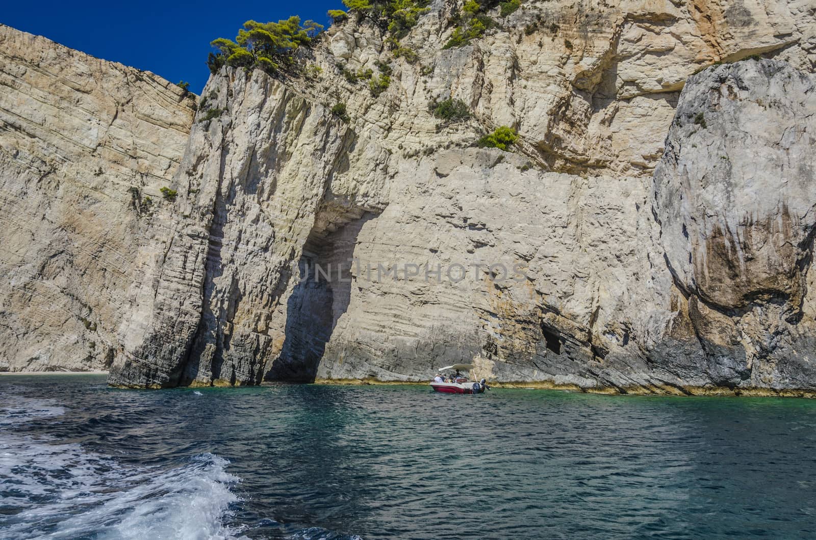 boat sailing among the irregularities of the high reefs off the coast of the island of zakynthos in the Ionian sea