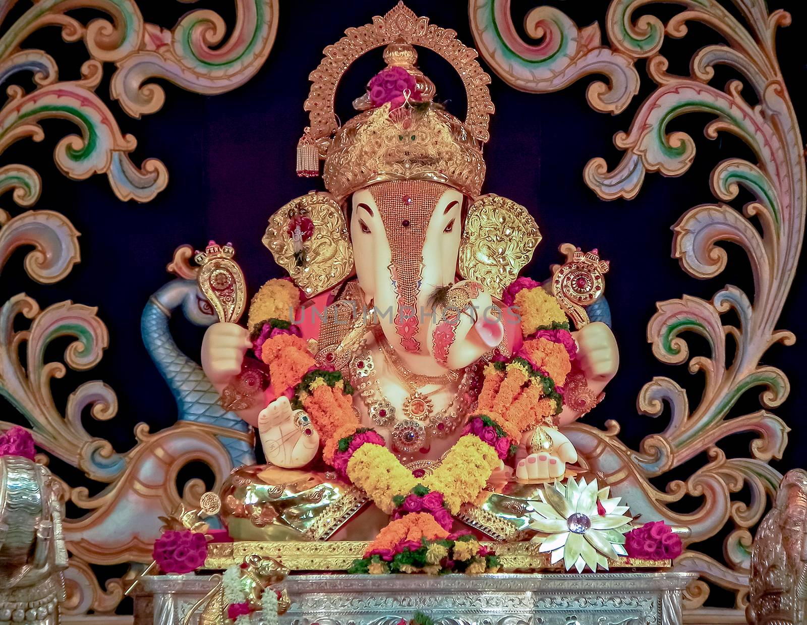 Closeup view of decorated and garlanded idol of Hindu God Ganesha in Pune, India.