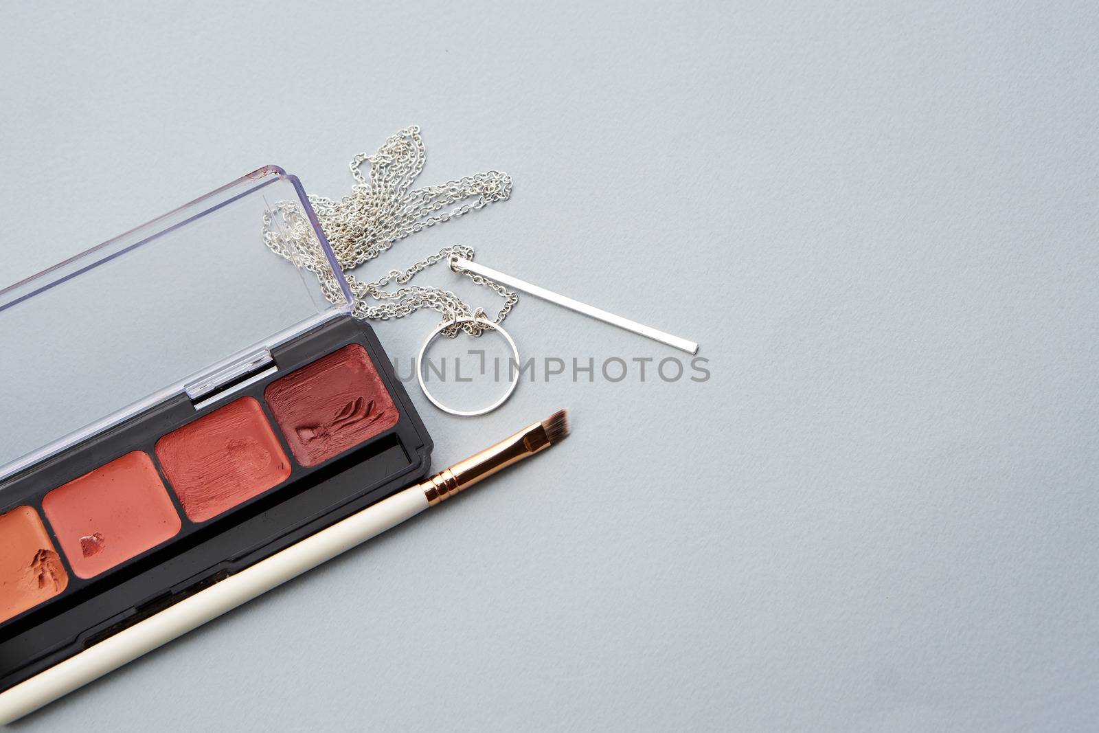 palette with lipstick and makeup brushes for makeup gray background by SHOTPRIME