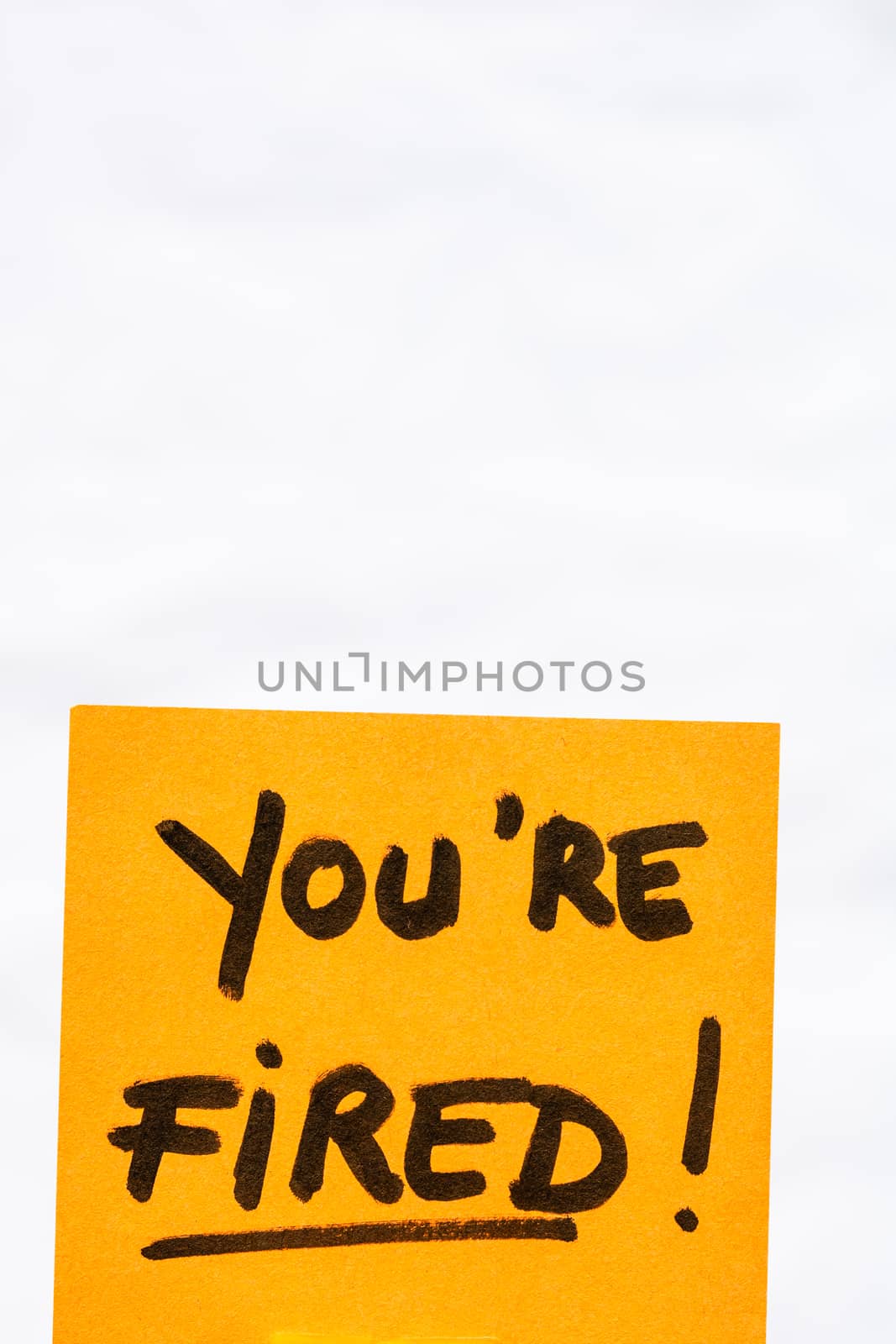 You are fired handwriting text close up isolated on orange paper with copy space.