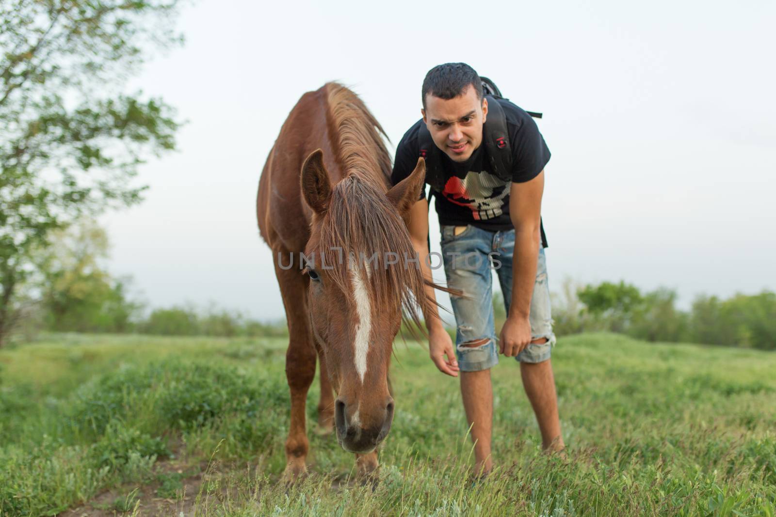 Guy with a horse in a green field. Communication with animals by Try_my_best