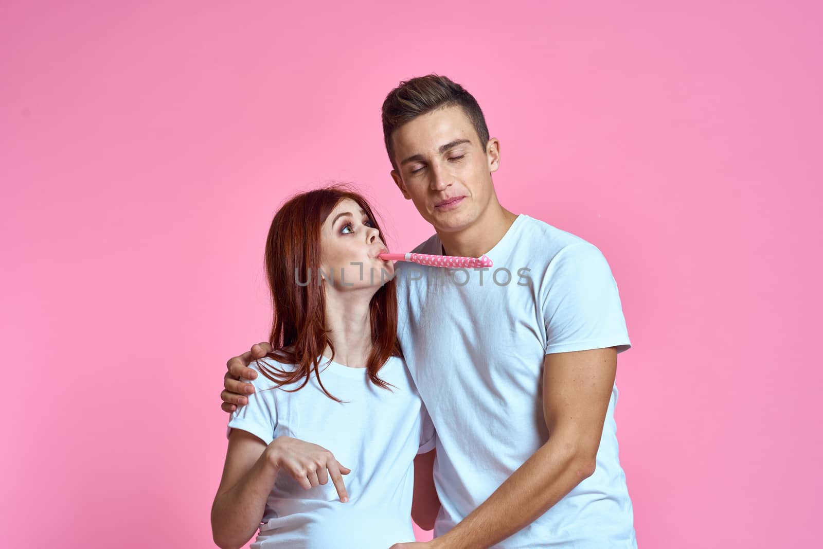 pregnant mom and happy father on pink background Young family waiting for baby. High quality photo