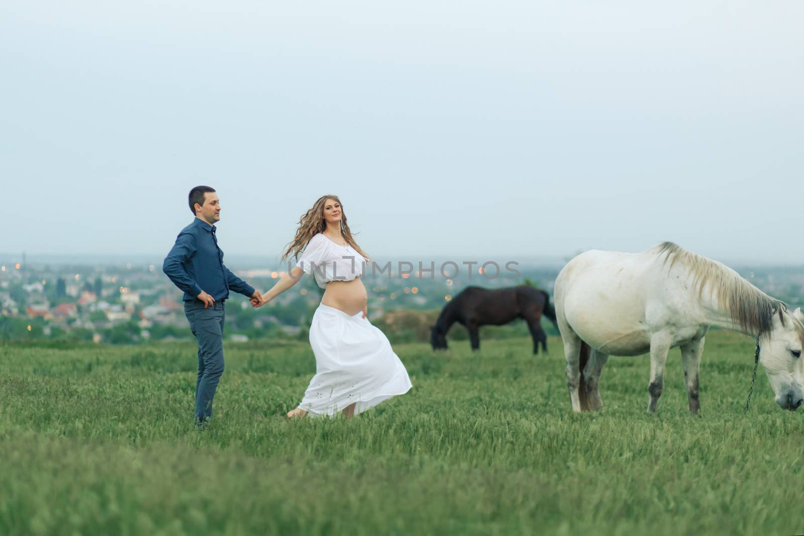 Rural couple on a green meadow communicates with animals. Pregnant wife. Therapy and relaxation for pregnant women by Try_my_best