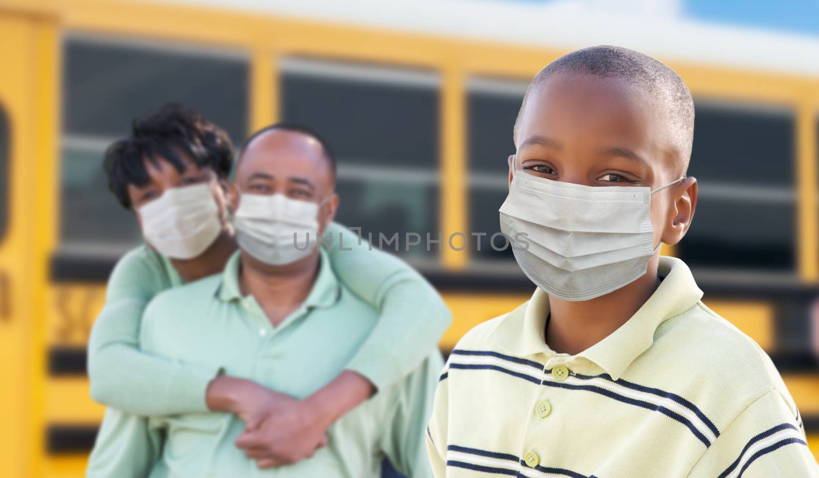 Young African American Student and Parents Near School Bus Wearing Medical Face Masks During Coronavirus Pandemic.