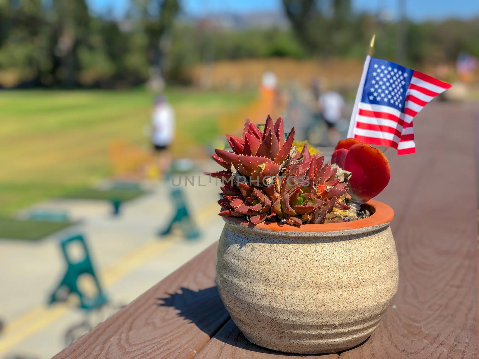 Patriotic flower pot with American flags and golfer on the background. American flag decoration.