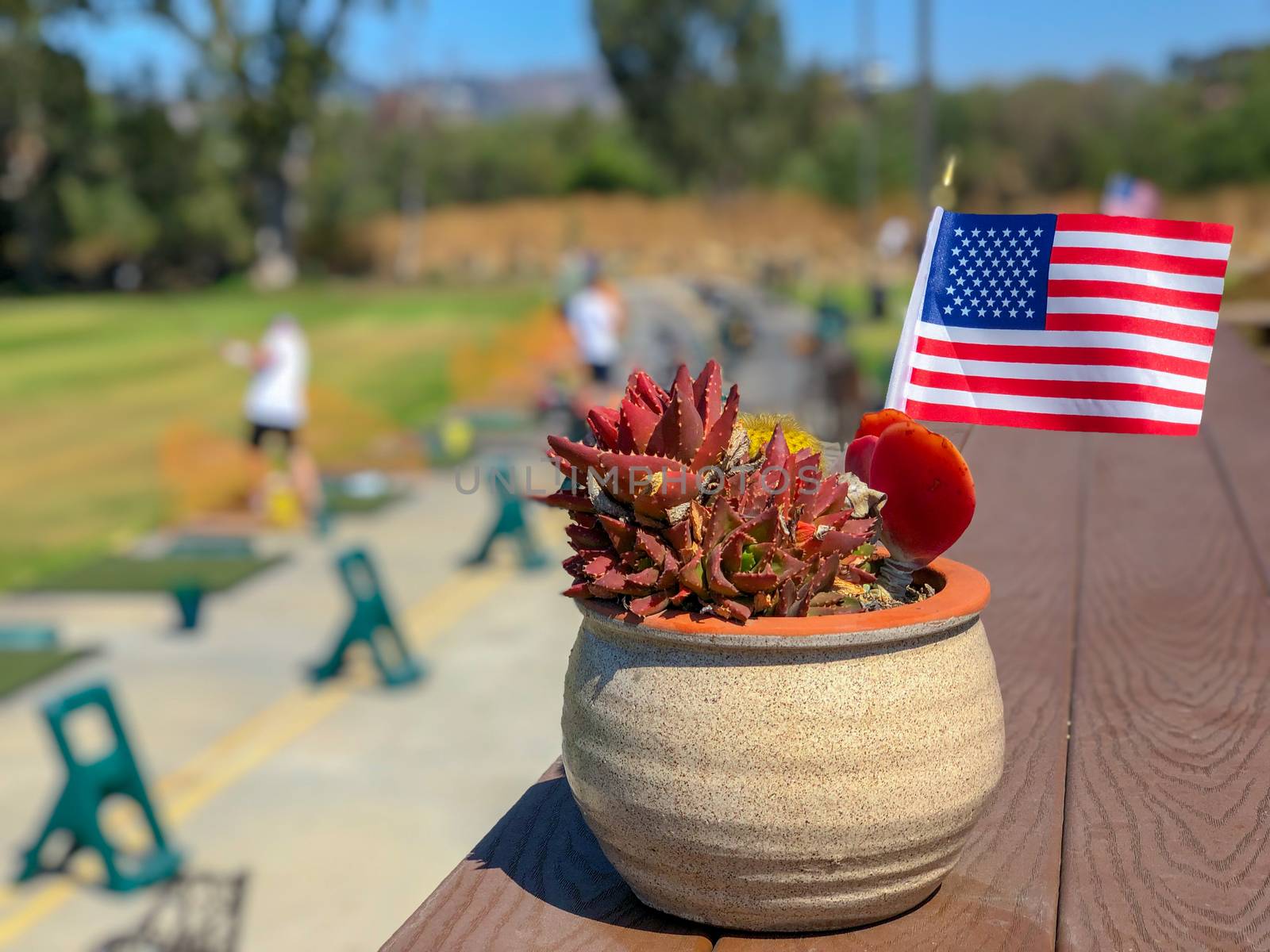 Patriotic flower pot with American flags and golfer on the background. American flag decoration.