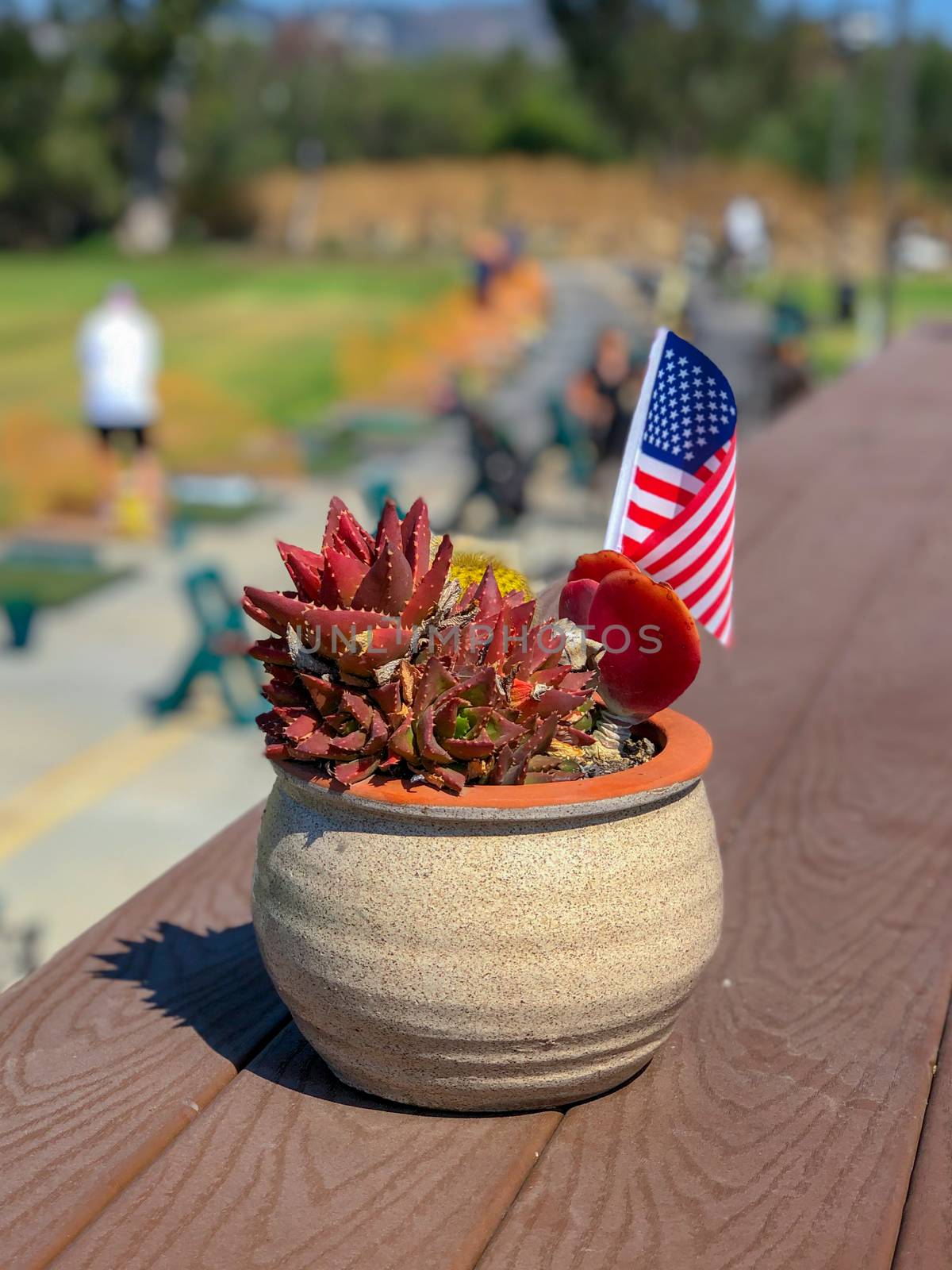 Patriotic flower pot with American flags and golfer on the background. American flag decoration.