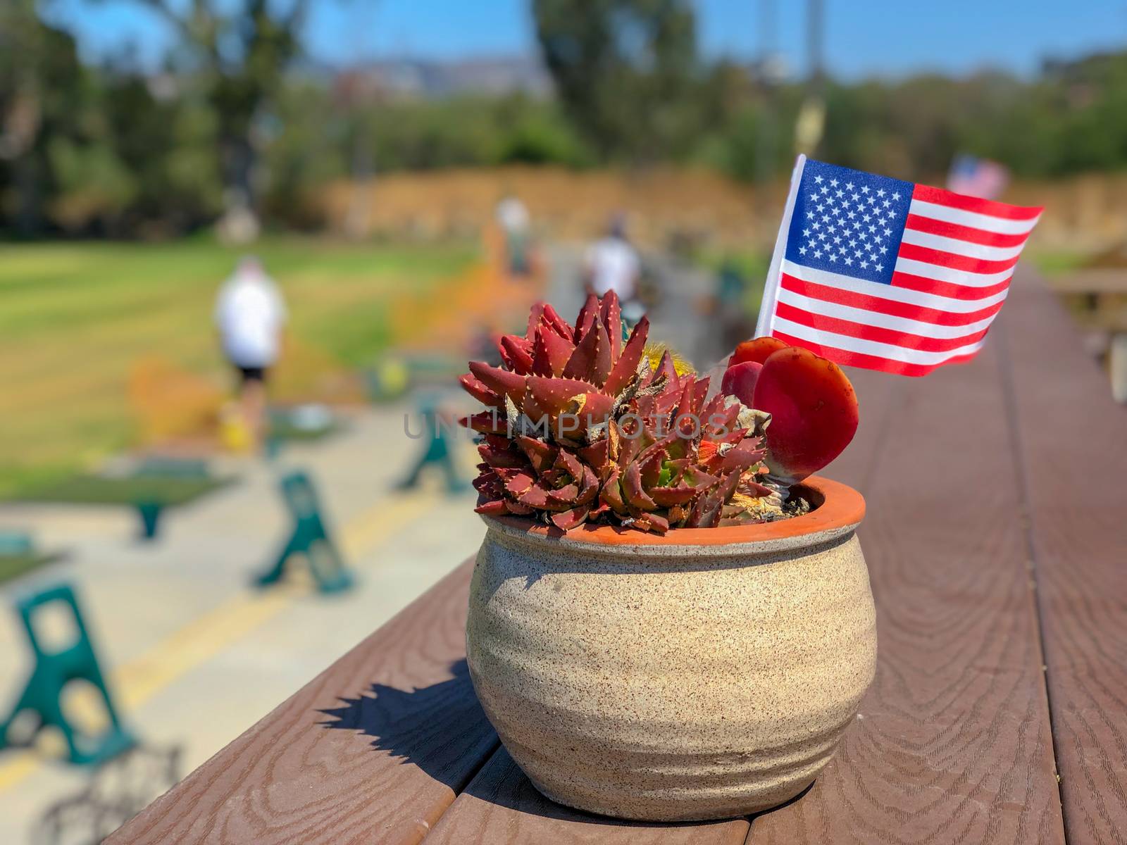 Patriotic flower pot with American flags and golfer on the background. American flag decoration.