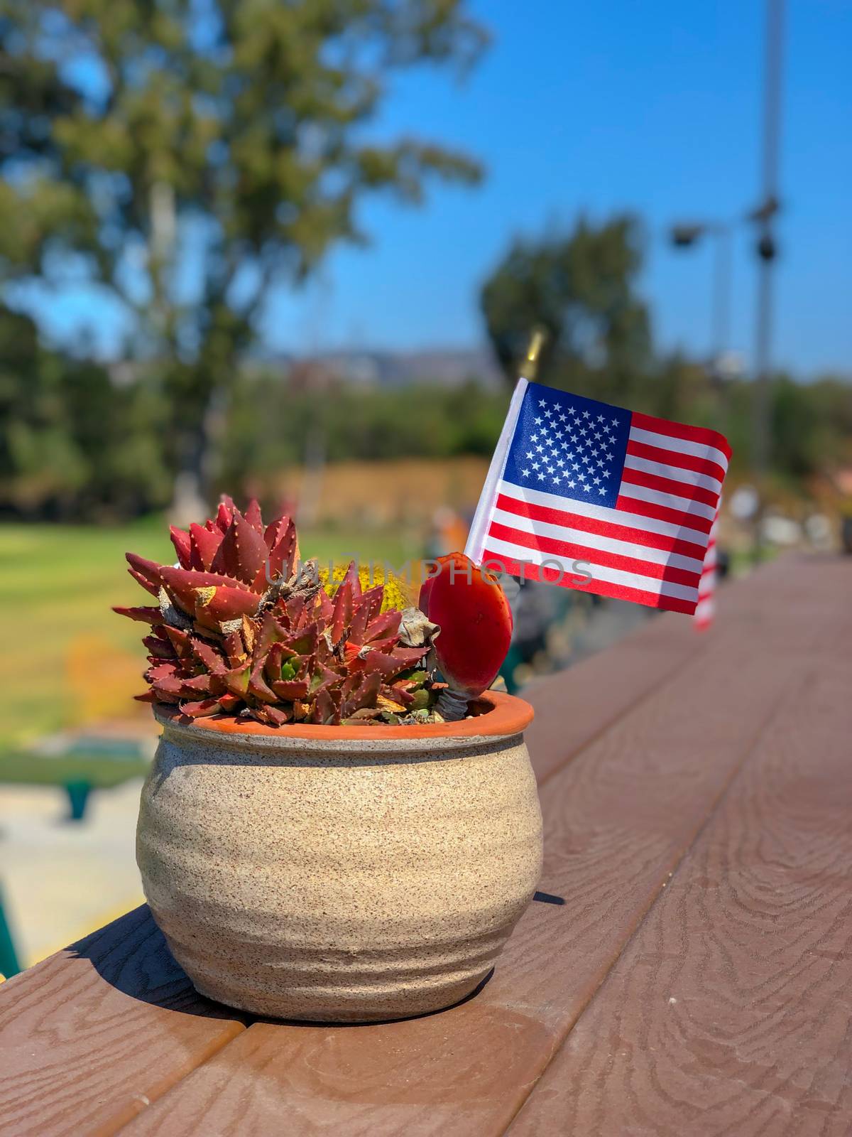 Patriotic flower pot with American flags and golfer on the background. American flag decoration.