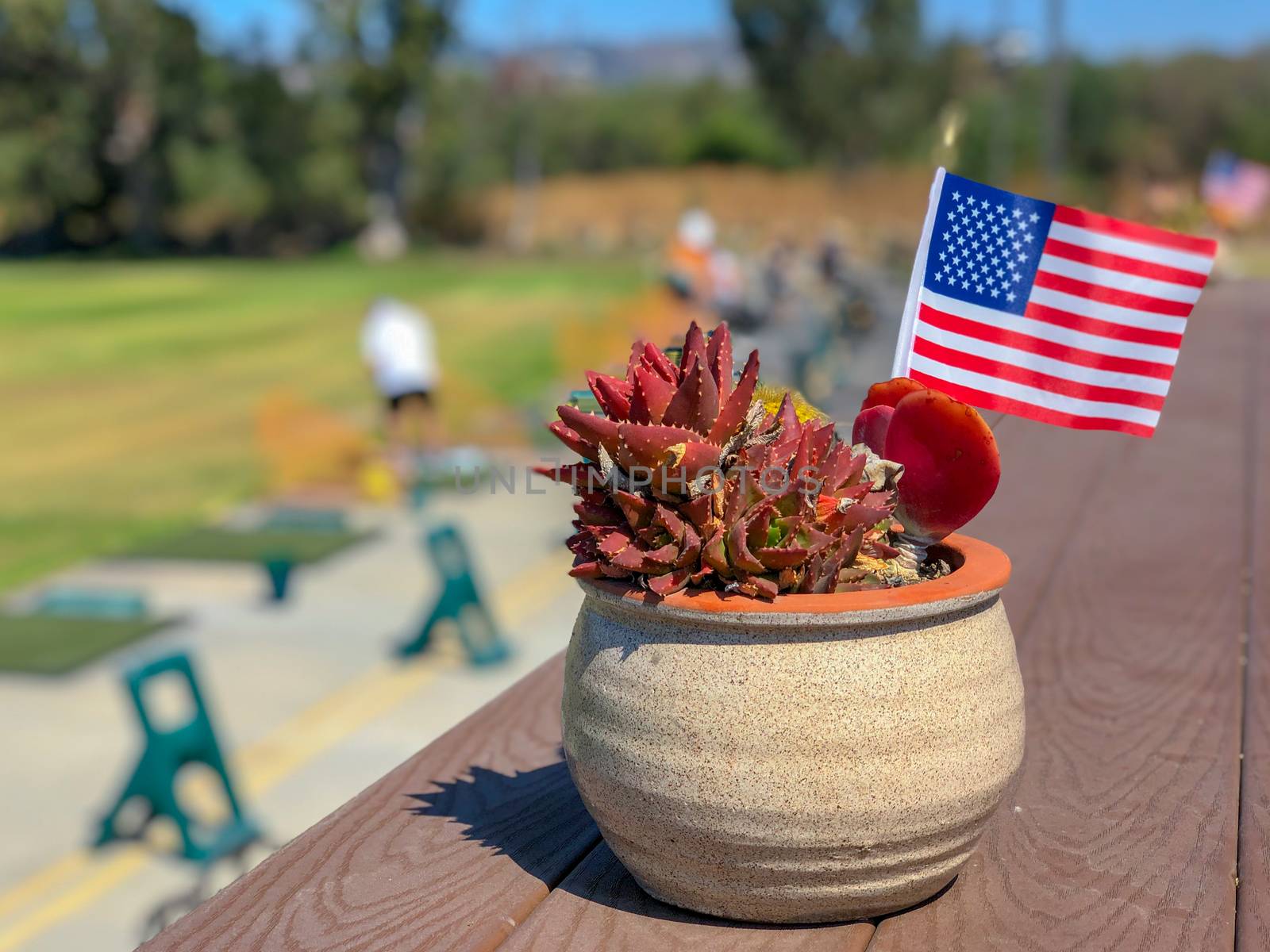 Patriotic flower pot with American flags and golfer on the background. American flag decoration.