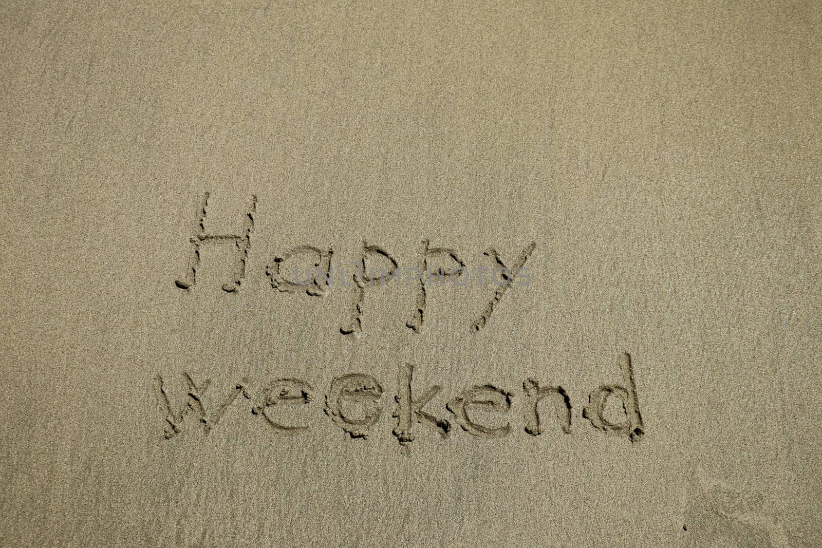 happy weekend written on a tropical white sand beach.