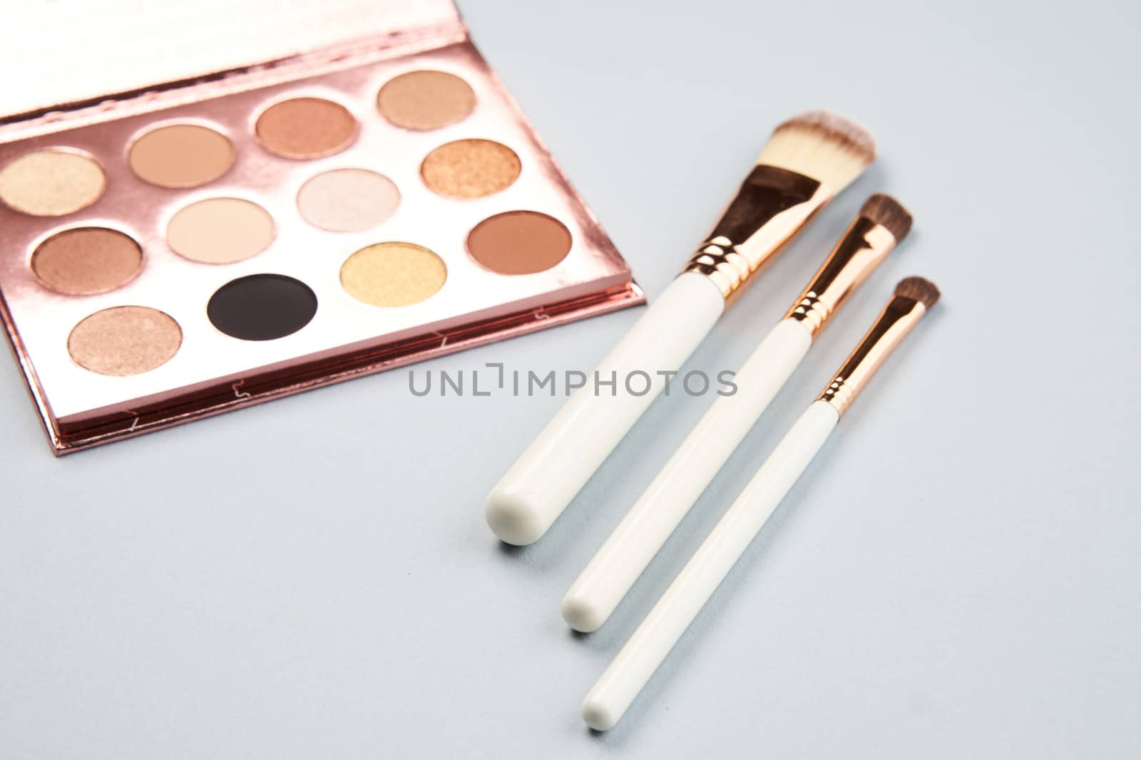 eyeshadow makeup brushes collection professional cosmetics accessories beads on gray background by SHOTPRIME
