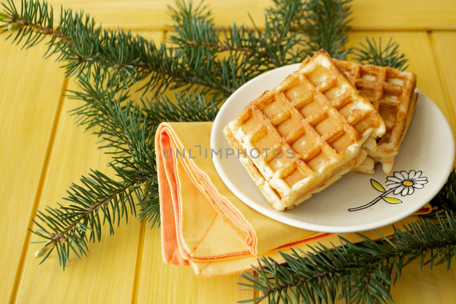 Homemade fresh golden waffles delicious breakfast. Christmas decoration on yellow background