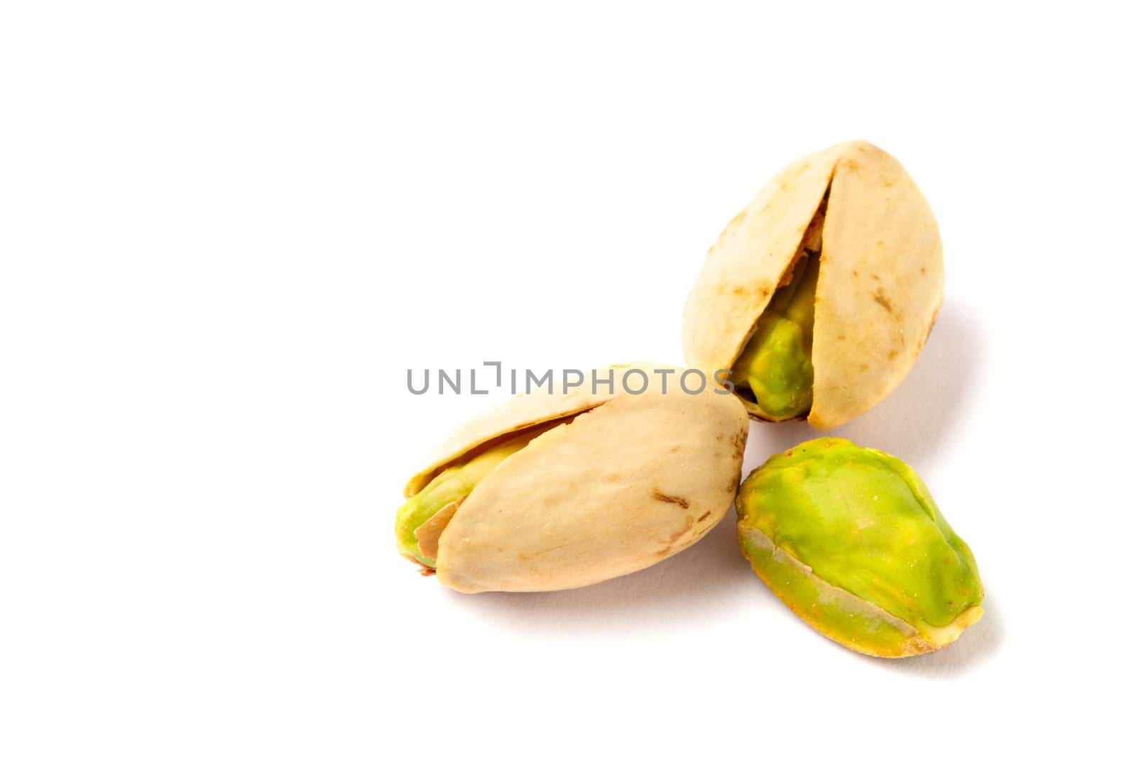 Some Pistachio nuts on a white background