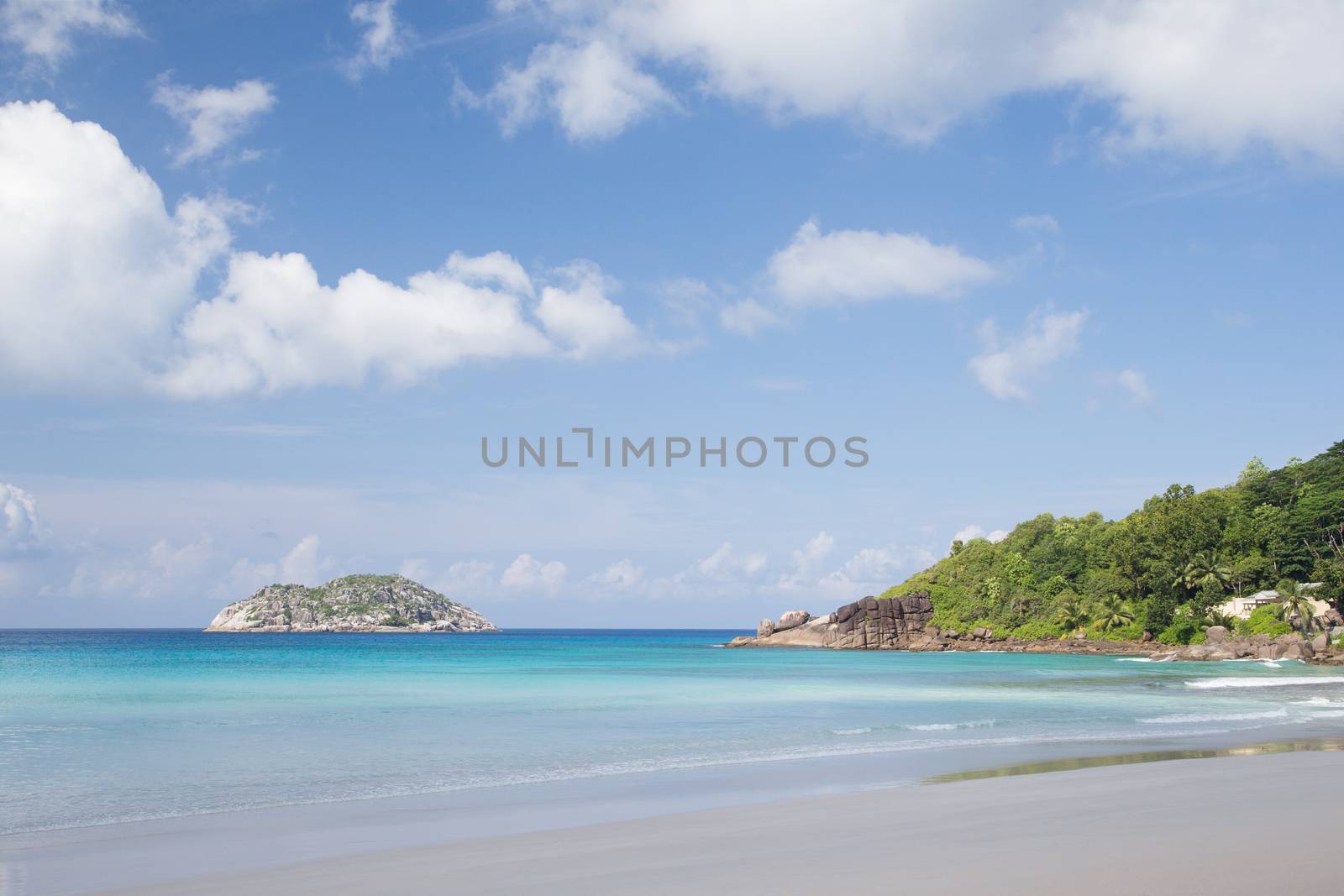 A beach on the Seychelles island with white sand and stones