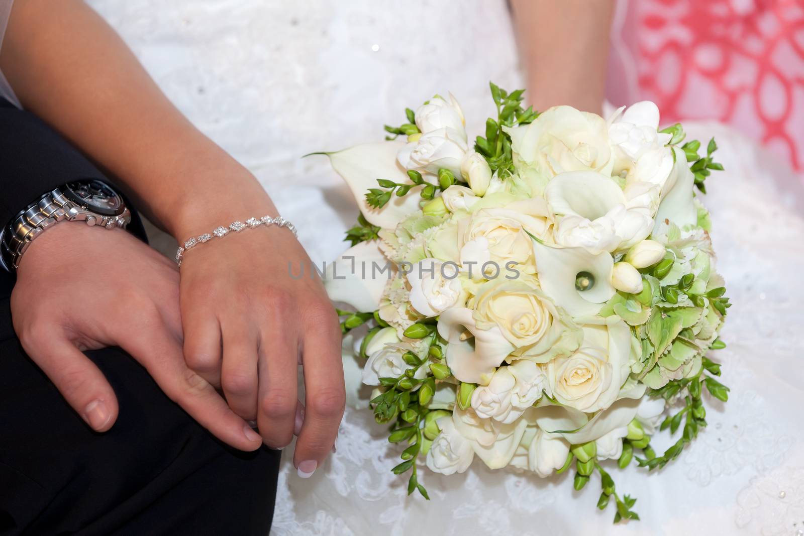 Bride and groom hold their hands romantically