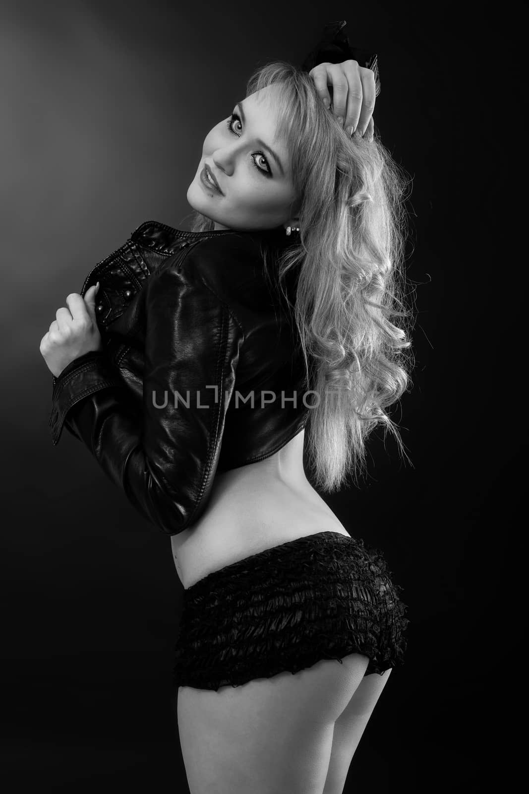 Young woman in black panties and black jacket is posing